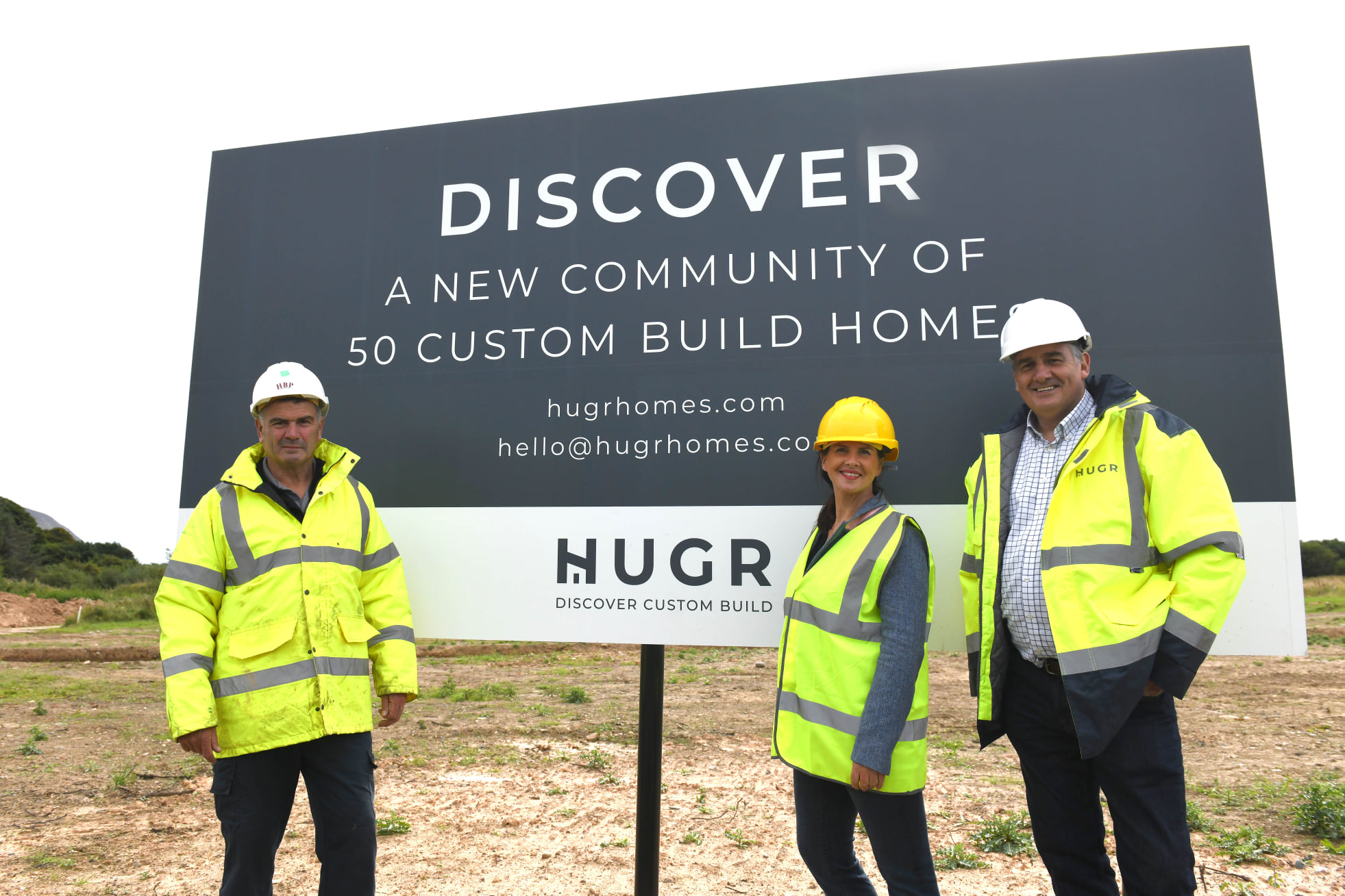 Hugr Homes Hugr Homes Sign and People at Wellbank ParkSign and People